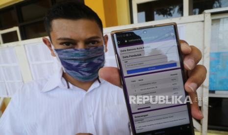 Wali Kota Kediri Abdullah Abu Bakar memperlihatkan aplikasi cekbansos.kedirikota.go.id berbasis Nomor Induk Kependudukan (NIK) di Kota Kediri, Jawa Timur, Jumat (1/5/2020). Pemerintah daerah setempat meluncurkan aplikasi tersebut guna memberikan kemudahan masyarakat mengecek NIK apakah bisa mendapatkan bantuan sosial sebagai warga terdampak COVID-19 dan juga berfungsi memantau siapa saja penerima bantuan sehingga terjamin transparansinya.