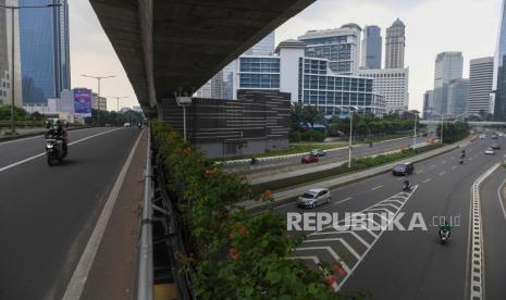 Pengendara melintasi kawasan jalan Sudirman yang lengang di Jakarta, Minggu (27/6/2021). Pembatasan kegiatan oleh pemerintah melalui PPKM Mikro hingga 5 Juli 2021 antara lain penutupan ruang publik, pembatasan operasional transportasi serta  penerapan protokol lebih ketat diharapkan dapat mengurangi penyebaran COVID-19 dimana fasilitas kesehatan telah penuh dalam menghadapi lonjakan pasien terkonfirmasi COVID-19. 