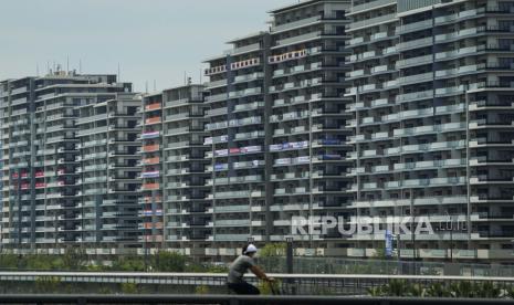 Seorang pria mengendarai sepedanya di dekat kampung atlet untuk Olimpiade dan Paralimpiade 2020, Kamis, 15 Juli 2021, di Tokyo, Jepang. 