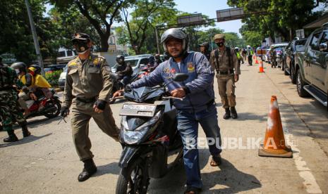 Petugas Satpol PP memberhentikan pengendara yang melanggar protokol kesehatan saat Operasi Yustisi Protokol COVID-19,  di Tangerang Selatan, Banten, Sabtu (19/9/2020). Operasi Yusitisi tersebut digelar dalam rangka peningkatan kedisiplinan masyarakat untuk mematuhi protokol kesehatan COVID-19 serta memberikan sanksi sosial bagi masyarakat yang melanggar.