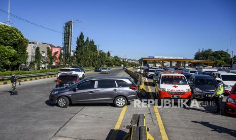 Petugas gabungan memutar balik kendaraan dengan pelat nomor luar Bandung saat penyekatan kendaraan di gerbang keluar Tol Pasteur, Kota Bandung, Selasa (6/7). Penyekatan tersebut merupakan tindak lanjut dari penerapan Pemberlakuan Pembatasan Kegiatan Masyarakat (PPKM) Darurat Jawa dan Bali yang ditujukan untuk menekan mobilitas kendaraan agar tidak masuk ke wilayah Kota Bandung demi mencegah penyebaran Covid-19. Foto: Republika/Abdan Syakura