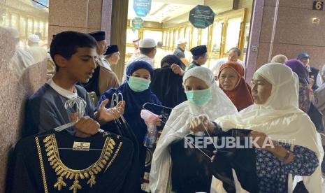 Pedagang abaya menawarkan barang dagangannya kepada jamaah haji Indonesia di sekitar masjid Nabawi, Madinah, Ahad (26/5/2024). Para pedagang abaya di sekitar Masjid Nabawi punya cara unik untuk menarik pembeli dari Indonesia. Mereka meneriakkan kata Jokowi, murah, dan seratus ribu yang jadi kata kunci efektif pedagang abaya di sekitar Masjid Nabawi. Sontak saja pedagang yang berteriak Jokowi, murah, seratus ribu, langsung diserbu ibu-ibu. Namun pedagang itu akan bersembunyi dan meninggalkan barang dagangannya ketika ada Askar yang datang. Harga satu baju abaya dijual Rp 100 ribu dan bisa bisa dibayar menggunakan uang rupiah.