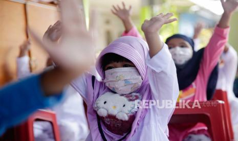 Anak-anak sekolah mengacungkan tangan saat mengikuti pelajaran di sekolah swasta di Depok, Indonesia, 16 Agustus 2021. Pemerintah Indonesia belum memutuskan untuk melanjutkan atau melonggarkan penerapan pembatasan kegiatan masyarakat (PPKM) level 4 yang akan berakhir hari ini 16 Agustus 2021. 