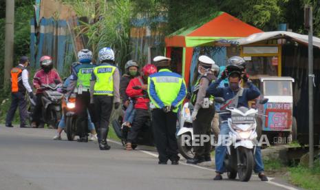 Petugas gabungan memeriksa kendaraan dari arah Subang, serta memperingatkan pengendara yang belum menerapkan sosial distancing dan memakai alat pelindung diri (APD) secara lengkap, di pos check point Pembatasan Sosial Berskala Besar (PSBB), Grafika Cikole, Kecamatan Lembang, Kabupaten Bandung Barat, Senin (27/4). Dengan adanya pos check point PSBB diharapkan masyarakat dapat mematuhi aturan pemerintah untuk memutus penyebatran wabah Covid-19