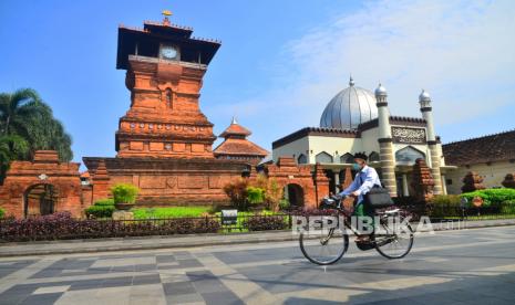 Warga melintas di depan Masjid Menara Kudus atau bernama resmi Masjid Al Aqsa Manarat Qudus di Desa Kauman, Kudus, Jawa Tengah, Rabu (13/4/2022). Rumah Mualaf MUI di Kudus Dampingi dan Bina Mualaf