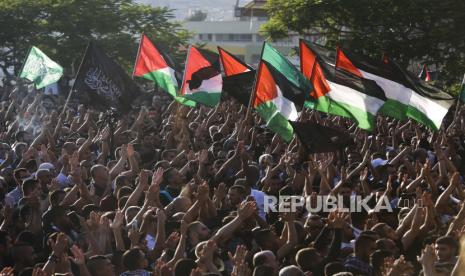 Pelayat Palestina meneriakkan slogan dan mengibarkan bendera Palestina selama pemakaman Mohammad Kiwan (17), yang keluarganya mengatakan dia tewas dalam bentrokan dengan polisi Israel di kota Arab, Umm al-Fahm, Kamis, 20 Mei 2021.