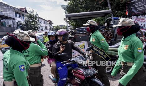 Petugas Satpol PP Kota Bandung menghentikan pengendara yang tidak memakai masker saat Operasi Disiplin Adaptasi Kebiasaan Baru (AKB) di Jalan Astana Anyar, Kota Bandung, Jumat (20/11). Operasi tersebut digelar dalam rangka peningkatan kedisiplinan masyarakat untuk mematuhi protokol kesehatan Covid-19 pada masa adaptasi kebiasaan baru (AKB). Foto: Abdan Syakura/Republika