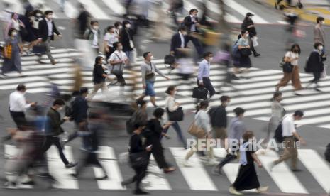 Pejalan kaki berjalan di sepanjang persimpangan Shibuya berebut di Tokyo, Jepang. 