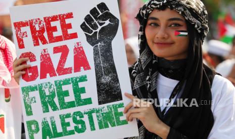 Warga membentangkan poster saat aksi bela Palestina di Jalan Gubernur Suryo, Surabaya, Jawa Timur, Ahad (12/11/2023). Aksi tersebut sebagai bentuk pembelaan dan kepedulian terhadap Palestina yang mengalami penderitaan akibat serangan militer Israel. 