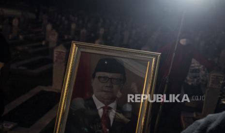 Pelayat berada di dekat foto almarhum Menteri Pendayagunaan Aparatur Negara dan Reformasi Birokrasi (PAN-RB) Tjahjo Kumolo seusai upacara pemakaman di Taman Makam Pahlawan Nasional Utama (TMPU) Kalibata, Jakarta, Jumat (1/7/2022). Tjahjo Kumolo meninggal dunia di Rumah Sakit Abdi Waluyo, Menteng, Jakarta, pada Jumat pukul 11.10 WIB setelah menjalani perawatan intensif di RS tersebut sejak pertengahan Juni 2022.