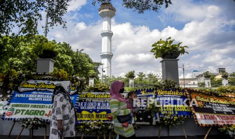 Sejumlah warga melintas di depan deretan karangan bunga ucapan belasungkawa atas wafatnya Wali Kota Bandung Oded M Danial di Jalan Dalem Kaum, Kota Bandung, Ahad (12/12). Ratusan karangan bunga tersebut sebagai bentuk penghargaan, penghormatan sekaligus duka cita atas wafatnya Wali Kota Bandung Oded M Danial pada Jumat (10/12). Foto: Republika/Abdan Syakura