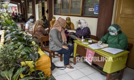 Sejumlah tenaga pendidik dan guru menjalani tahap pemeriksaan kesehatan sebelum disuntik vaksin Covid-19 di SDN 023 Pajagalan, Kota Bandung, Rabu (14/4). Dinas Kesehatan Kota Bandung terus menggencarkan vaksinasi Covid-19 terhadap guru dan tenaga pendidik jelang pembelajaran tatap muka pada Juli mendatang. Hingga saat ini, sudah terdapat 2.744 guru dan tenaga pendidik yang telah menerima vaksin Covid-19 dosis pertama. Foto: Republika/Abdan Syakura