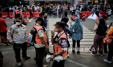 Petugas Satpol PP mengimbau warga untuk menggunakan masker. Disiplin protokol kesehatan sangat penting untuk mencegah penularan Covid-19 di tengah gempuran mutasi subvarian Omicron.