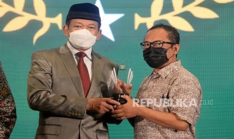 Ketua Badan Amil Zakat Nasional (BAZNAS) RI KH. Noor Achmad memberikan pengahargaan kepada Wakil Pemimpin Redaksi Republika Nur Hasan Murtiaji dalam acara Baznas Award 2022 di Jakarta, Senin (17/1/2022). Republika mendapatkan pengargaan Baznas Award 2022 Ketegori Media Pendukung Gerakan Zakat Indonesia pada Media Cetak.Prayogi/Republika