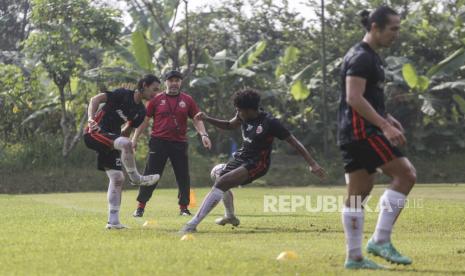 Pelatih Persija Thomas Doll (kedua kiri) memberikan arahan kepada pemain saat latihan di Lapangan Nirwana Park, Bojongsari, Depok, Jawa Barat, Rabu (25/5/2022). Persija Jakarta merekrut pelatih dan asisten pelatih baru untuk memperkuat tim guna menghadapai kompetisi Liga 1. ANTARA FOTO/Asprilla Dwi Adha/tom.