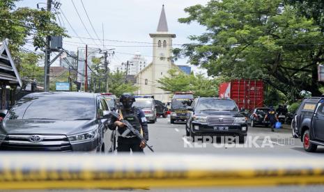 Seorang petugas polisi berjaga di dekat sebuah gereja tempat ledakan meledak di Makassar, Sulawesi Selatan, Indonesia, Minggu, 28 Maret 2021. Polisi di Indonesia mengatakan setidaknya satu pelaku bom bunuh diri telah meledak di luar katedral Katolik Roma yang penuh sesak selama Misa Minggu, melukai beberapa orang