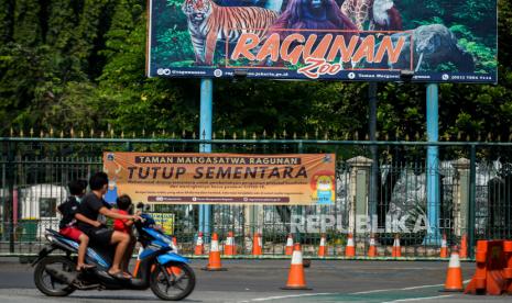 Pengendara melintas di area pintu gerbang Taman Margasatwa Ragunan. Jakarta, Ahad (27/6). Taman Margasatwa Ragunan tutup sementara hingga waktu yang belum ditentukan menyusul kebijakan Pemprov DKI Jakarta terkait Pemberlakuan Pembatasan Kegiatan Masyarakat (PPKM) mikro akibat melonjaknya kasus harian Covid-19 di DKI Jakarta. Republika/Thoudy Badai