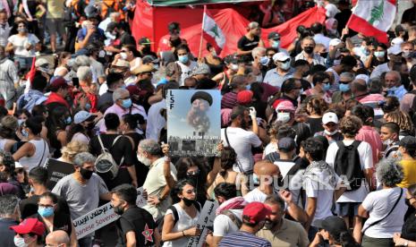 Rakyat Lebanon memegang plakat selama protes setelah ledakan, di Beirut, Lebanon, 08 Agustus 2020. Orang-orang berkumpul untuk melakukan apa yang disebut 