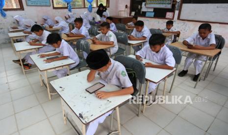 Sejumlah siswa madrasah mengerjakan soal saat mengikuti ujian akhir semester berbasis digital atau 