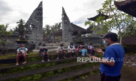 Guru SD Negeri 5 Yehembang Kauh melatih siswa kelas IV cara mengoperasikan aplikasi belajar daring dengan memanfaatkan wifi gratis di Pura Puseh Banjar Kedisan, Desa Yehembang Kauh, Jembrana, Bali, Kamis (4/2). Pemerintah menyediakan anggaran sebesar Rp 26 triliun untuk memperluas jangkauan jaringan internet ke seluruh daerah di Indonesia. 