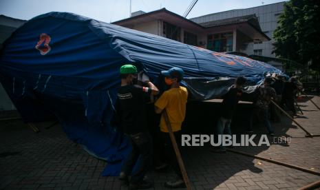 Relawan membangun tenda barak di Rumah Sakit Umum Pusat Dr. Sardjito, Sleman, DI Yogyakarta, Minggu (27/6/2021). Pembangunan tenda barak tersebut untuk melakukan screening dan penampungan sementara pengunjung di Instalasi Gawat Darurat (IGD) agar tidak terjadi kerumunan serta  mengantisipasi penularan COVID-19. 