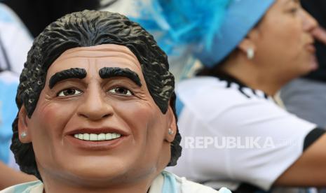 Seorang pendukung Argentina mengenakan topeng Diego Maradona sebelum pertandingan sepak bola grup C Piala Dunia 2022 antara Argentina dan Arab Saudi di Stadion Lusail di Lusail, Qatar, 22 November 2022.