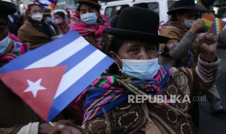 Seorang wanita memegang bendera Kuba selama pawai mendukung pemerintah Kuba, dekat kedutaan AS di La Paz, Bolivia, Rabu, 14 Juli 2021. 