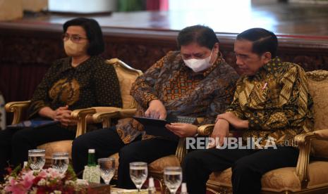 Presiden Joko Widodo (kanan) berbincang dengan Menko Perekonomian Airlangga Hartarto (tengah) disaksikan Menkeu Sri Mulyani (kiri) saat acara penyerahan kredit usaha rakyat (KUR) klaster kepada pelaku UMKM di Istana Negara, Jakarta, Senin (19/12/2022). Menteri Koordinator Bidang Perekonomian Airlangga Hartarto mengatakan, nilai perdagangan ekspor Indonesia pada 2022 mengalami peningkatan signifikan dengan nilai ekspor sebesar 268 miliar dolar AS.