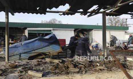 Warga Ukraina berupaya menyelamatkan barang-barang di pasar lokal yang rusak setelah penembakan menghantam kota Shevchenkove, wilayah Kharkiv, timur laut Ukraina, 09 Januari 2023, di tengah invasi Rusia. Dua orang tewas dan lima lainnya luka-luka, di antaranya seorang anak, akibat serangan roket di desa Shevchenkive di distrik Kupyansk, tulis kepala Administrasi Negara Daerah Kharkiv Oleh Synehubov di telegram. Pasukan Rusia pada 24 Februari 2022, memasuki wilayah Ukraina, memulai konflik yang memicu kehancuran dan krisis kemanusiaan.