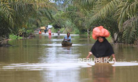 Sejumlah warga melintasi banjir.