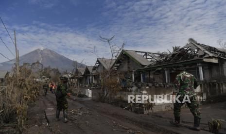 Prajurit TNI melintas di depan rumah warga yang rusak akibat awan panas guguran Gunung Semeru di Dusun Curah Kobokan, Pronojiwo, Lumajang, Jawa Timur, Rabu (8/12/2021). Dusun Curah Kobokan merupakan salah satu lokasi terparah terdampak awan panas guguran Gunung Semeru dan salah satu dusun terdekat dengan kawah Gunung Semeru 