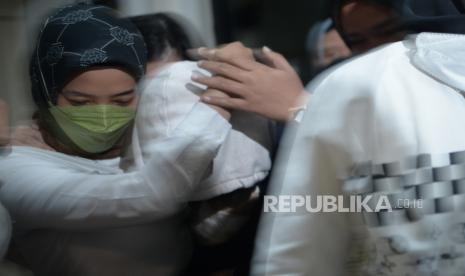 Petugas Kepolisian membawa kekasih tersangka penganiayaan terhadap David Ozora,  Mario Dandy, berinisial AG menaiki mobil usai diperiksa di Unit Pelayanan Perempuan dan Anak Ditreskrimum Polda Metro Jaya, Jakarta, Rabu (8/3/2023).  Direktorat Resere Kriminal Umum (Ditreskrimum) memutuskan melakukan penahanan terhadap AG setelah dilakukan pemeriksaan selama 6 jam. AG ditahan di Lembaga Penyelenggara Kesejahteraan Sosial (LPKS) selama 7 hari usai ditetapkan sebagai anak yang berkonflik dengan hukum.