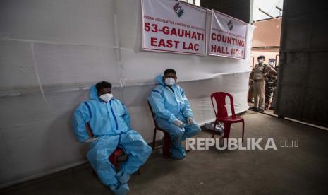 Agen penghitung dengan pakaian pelindung beristirahat selama penghitungan suara pemilihan majelis negara bagian Assam di Gauhati, India, Minggu, 2 Mei 2021. Dengan rumah sakit India berjuang untuk mengamankan pasokan oksigen yang stabil, dan lebih banyak pasien COVID-19 meninggal di tengah kekurangan, pengadilan di New Delhi mengatakan akan mulai menghukum pejabat pemerintah karena gagal mengirimkan barang-barang penyelamat nyawa.