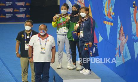 Atlet renang putri Jawa Timur Adinda Larasati (kedua kanan), Atlet Riau Azzahra Permatahani (ketiga kanan) dan atlet Jawa Barat Raina Saumi (kanan) berfoto bersama Ketua Umum KONI Pusat Marciano Norman (kedua kiri bawah) saat Upacara Penghormatan Pemenang final 200 meter Gaya Kupu-Kupu Putri PON Papua di Stadion Akuatik, Kampung Harapan, Kabupaten Jayapura, Papua, Kamis (14/10/2021). Atlet renang putri Jawa Timur Adinda Larasati berhasil meraih medali emas dengan catatan waktu 2 menit 14,53 detik sementara medali perak diraih atlet Riau Azzahra Permatahani (2 menit 17,04 detik) dan medali perunggu diraih atlet Jawa Barat Raina Saumi (2 menit 19,99 detik). 