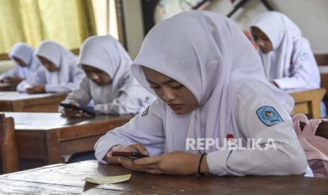 Siswa mengerjakan soal ujian menggunakan telepon genggam saat mengikuti Penilaian Akhir Semester (PAS) di SMK Negeri 1 Ciamis, Kabupaten Ciamis, Jawa Barat, Senin (5/12/2022). Bolehkah tidak Berpuasa Ramadhan karena Belajar untuk Ujian?