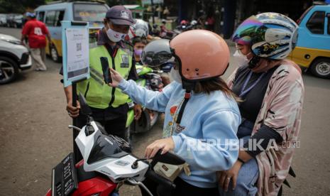 Pengunjung memindai kode batang pada aplikasi PeduliLindungi sebelum memasuki Pasar Anyar, Kota Tangerang, Banten, Selasa (26/10/2021). Pemerintah Kota Tangerang mulai menerapkan penggunaan aplikasi PeduliLindungi sebelum memasuki pasar tradisonal sebagai upaya pencegahan penyebaran COVID-19. 