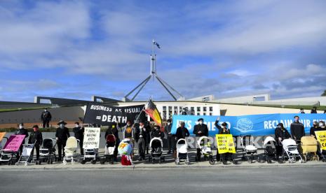  Aktivis Extinction Rebellion (XR) berpose untuk foto saat mereka menggelar parade pemakaman kereta bayi kosong selama protes perubahan iklim di luar Gedung Parlemen di Canberra, Wilayah Ibu Kota Australia, Australia, 21 Oktober 2021. Menurut Extinction Rebellion Australia, kereta bayi putih kosong melambangkan 