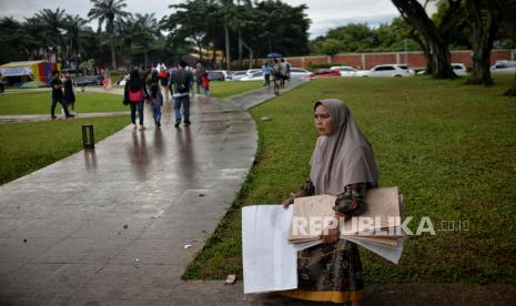 Penyedia jasa tikar menunggu penyewa di kawasan Taman Mini Indonesia Indah (TMII), Jakarta, Sabtu (31/12/2022). Menjelang malam pergantian tahun Baru 2023, sejumlah pengunjung mulai memadati kawasan TMII pada sore hari meski cuaca dalam kondisi mendung. Sementara pada perayaan malam pergantian tahun TMII membuka layanan pengunjung selama 24 jam. Republika/Thoudy Badai