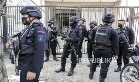 Anggota Brimob berpatroli di luar gedung pengadilan Surabaya menjelang sidang pertama penyerbuan stadion Kajuruhan di Surabaya, Jawa Timur, Indonesia, 16 Januari 2023. Pada 01 Oktober 2022 polisi menembakkan gas air mata untuk menghentikan suporter sepak bola memasuki stadion Kanjuruhan lapangan usai pertandingan antara Arema FC dan Persebaya Surabaya di Jawa Timur, menimbulkan kepanikan dan injak-injak yang menewaskan 135 orang. Pihak berwenang Indonesia memindahkan persidangan para tersangka penyerbuan dari Malang ke Surabaya karena masalah keamanan.