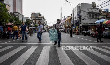 Sejumlah pedagang menjajakan dagangannya saat penutupan jalan di Jalan Otto Iskandardinata, Kota Bandung, Jumat (18/6). Pemerintah Kota Bandung dan Polrestabes Bandung mulai menerapkan kebijakan buka tutup di sejumlah ruas jalan protokol dari pukul 14.00 WIB hingga 16.00 WIB serta pukul 18.00 WIB hingga 05.00 WIB selama 14 hari ke depan. Penutupan tersebut bertujuan untuk menekan mobilitas masyarakat sekaligus meminimalisir warga luar kota masuk ke Kota Bandung demi mencegah penyebaran Covid-19. Foto: Republika/Abdan Syakura