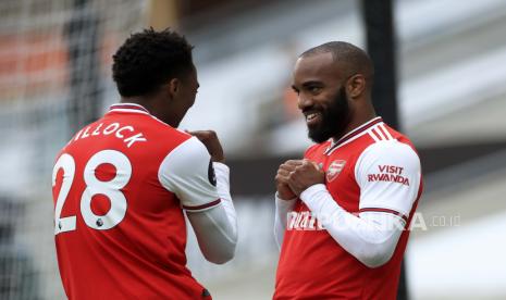 Arsenal Alexandre Lacazette merayakan dengan Joe Willock, kiri, setelah mencetak gol kedua timnya selama pertandingan sepak bola Liga Premier Inggris antara Wolverhampton Wanderers dan Arsenal di Stadion Molineux di Wolverhampton, Inggris, Sabtu, 4 Juli 2020. 