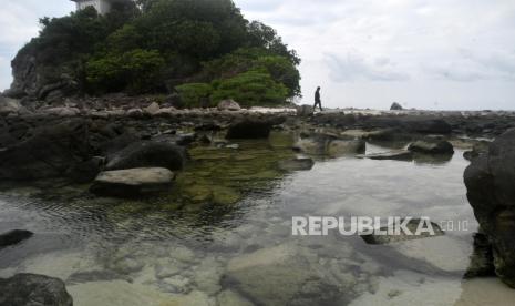 Wisatawan berjalan di pantai Pulau Senoa, Kabupaten Natuna, Kepulauan Riau. 