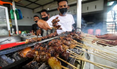 Pekerja membakar kuliner sate. (Ilustrasi)