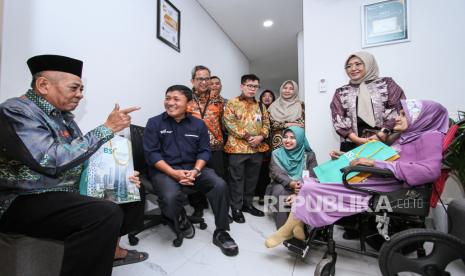 Wakil Direktur Utama Bank Syariah Indonesia (BSI) Bob Tyasika Ananta (kedua kiri) berbincang dengan nasabah penyandang disabilitas dan lansia saat berkunjung di BSI Kantor Cabang Pembantu (KCP) Gresik Kota Baru, Gresik, Jawa Timur, Senin (4/12/2023). BSI melengkapi infrastruktur ramah disabilitas seperti jalur landai (rampa), toilet, area parkir, dan ruang tunggu khusus pada 16 cabang di Indonesia guna memperkuat layanan inklusif sekaligus memperingati Hari Disabilitas Internasional. 