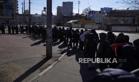  Orang-orang menunggu dalam antrian di luar sebuah supermarket di pusat Kyiv, Ukraina, Senin, 28 Februari 2022. Presiden Vladimir Putin secara dramatis meningkatkan ketegangan Timur-Barat dengan memerintahkan pasukan nuklir Rusia dalam siaga tinggi menyusul sanksi baru yang melumpuhkan dari Barat yang memaksa Bank Sentralnya menaikkan tajam suku bunga utamanya pada hari Senin untuk menyelamatkan rubel dari keruntuhan.