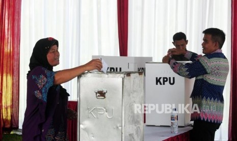 Warga memasukan surat suara pada Pilkada serentak 2018 di TPS 017, Desa Bojong Koneng, Babakan Madang, Bogor, Jawa Barat, Rabu (27/6).