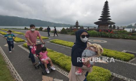 Wisatawan menikmati pemandangan objek wisata Ulun Danu Beratan saat liburan Maulid Nabi Muhammad SAW di Tabanan, Bali, Rabu (20/10/2021). Jumlah kunjungan wisatawan di objek wisata tersebut mengalami peningkatan dengan rata-rata 300 orang pada hari libur dan 100 orang pada hari biasa yang didominasi wisatawan domestik sejak dibuka pada Jumat (10/9/2021). ANTARA FOTO/Nyoman Hendra Wibowo/aww.