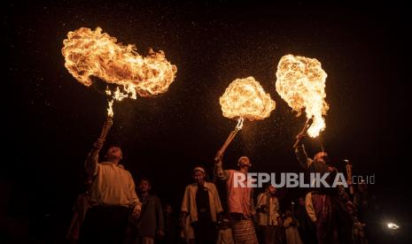 Umat muslim beratraksi sembur api saat mengikuti pawai obor menyambut Tahun Baru Islam 1 Muharram 1444 Hijriah di kawasan Manggarai, Jakarta Selatan, Jumat (29/7/2022) malam.  Mengapa Muslim Merayakan Tahun Baru Islam di Tengah Musim Panas?