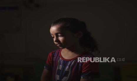 Maya Abu Muawad, 8, berpose di sebuah sekolah yang dikelola oleh PBB di mana keluarganya berlindung setelah rumah mereka dihancurkan selama perang 11 hari di Jalur Gaza utara, Jumat, 11 Juni 2021. Setelah serangan udara Israel di rumah keluarga, Maya dipisahkan dari ibunya. Sendirian dan ketakutan, dia naik ambulans ke tempat yang lebih aman. Selama 15 menit, dia dikurung di dalam kendaraan yang meratap dengan orang yang sekarat dan seorang anak laki-laki yang terluka, tetangganya.