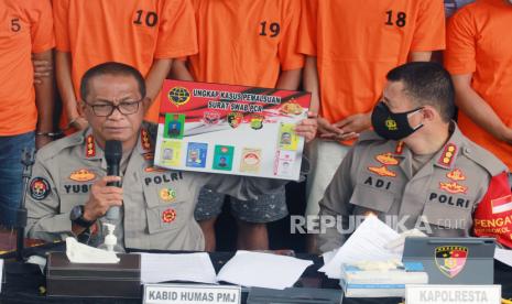 Kabid Humas Polda Metro Jaya Kombes Pol Yusri Yunus (kiri) didampingi Kapolres Bandara Soetta Kombes Pol Adi Ferdiyan Saputra (kanan) menunjukkan barang bukti kejahatan saat rilis pemalsuan surat bebas COVID-19 di Mapolresta Bandara Soekarno Hatta, Tangerang, Banten, Senin (18/1/2021). Dalam pengungkapan tersebut polisi berhasil mengamankan 15 orang pelaku sindikat pemalsu surat bebas COVID-19 yang sudah empat bulan menjalankan aksinya di Bandara Soetta, serta meraup pendapatan sekitar Rp1,5 miliar. 